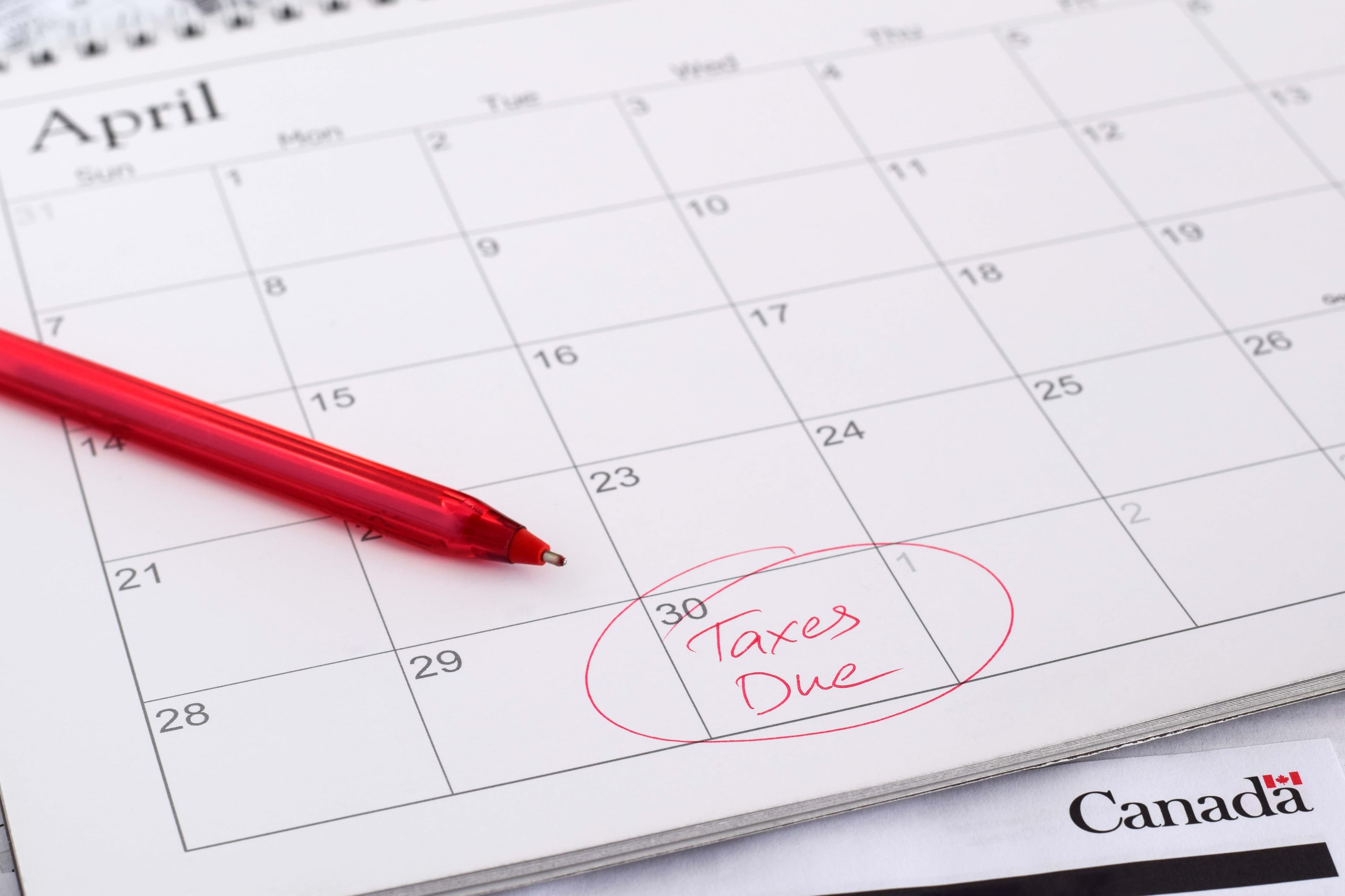 April calendar with "Taxes Due" circled on the 30th, red pen, Canada document.